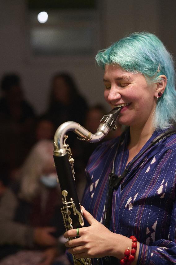 photo of Emily Suzanne Shapiro playing bass clarinet and laughing